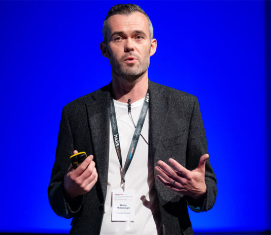 Snappy Group receives seven figure investment from Virgin Money Barry McGonagle, chief financial officer at Snappy Group, stands on a stage with a blue backdrop delivering a talk.