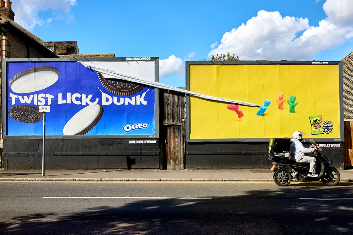 Image of the first UK marketing campaign for Sour Patch Kids featuring a billboard with the sweets on them tearing down another advert for Oreo.