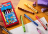 Stabilo rolls out Paw Patrol collection A pack of Stabilo Paw Patrol Trio Scribbi pens sits on a desk with the pans scattered across it with other stationary and pieces of paper.