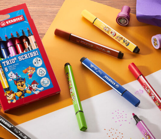 Stabilo rolls out Paw Patrol collection A pack of Stabilo Paw Patrol Trio Scribbi pens sits on a desk with the pans scattered across it with other stationary and pieces of paper.
