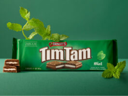 Tim Tam Mint hits Waitrose store shelves A pack of Arnott's Tim Tam Mint sits on a green table against a green background with mint sprigs around the pack.