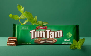 Tim Tam Mint hits Waitrose store shelves A pack of Arnott's Tim Tam Mint sits on a green table against a green background with mint sprigs around the pack.