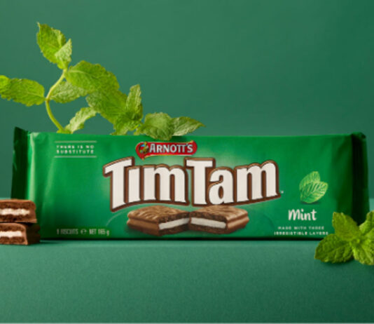 Tim Tam Mint hits Waitrose store shelves A pack of Arnott's Tim Tam Mint sits on a green table against a green background with mint sprigs around the pack.